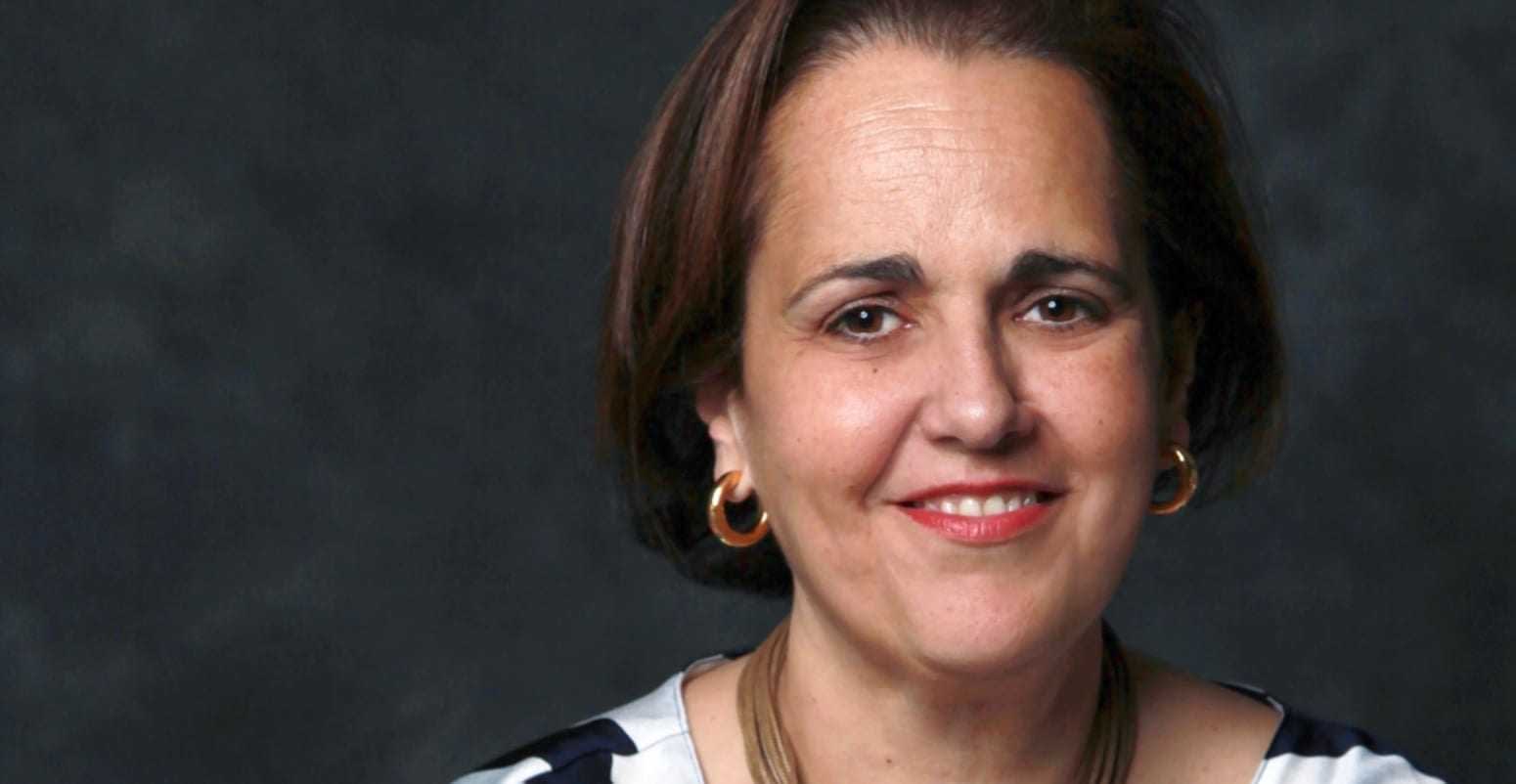 Portrait of a woman with short brown hair wearing hoop earrings and a striped top. - Olive Oil Times