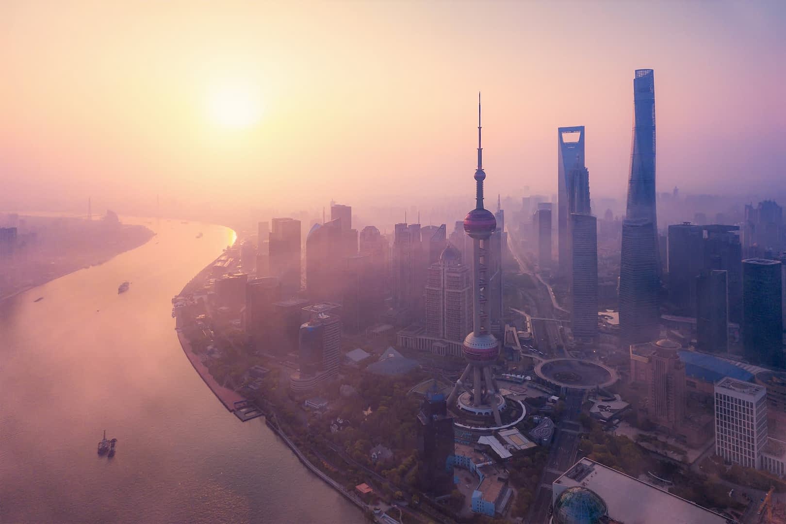 Vista aérea do horizonte de Xangai com a Torre Pérola Oriental e arranha-céus durante o pôr do sol. - Olive Oil Times