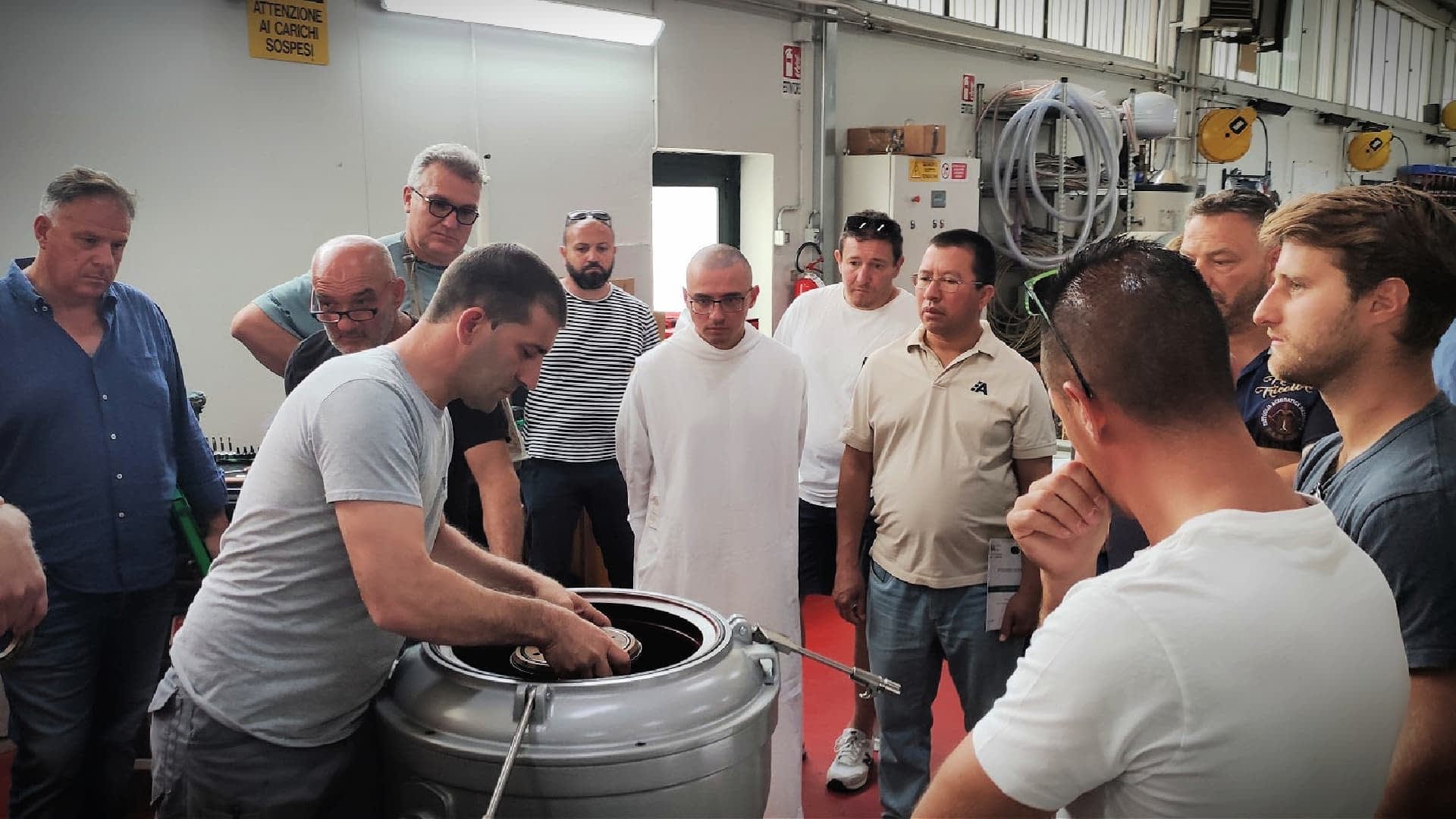 Bir tesiste zeytinyağı üretim sürecinin gösterimini izleyen bir grup birey. - Olive Oil Times