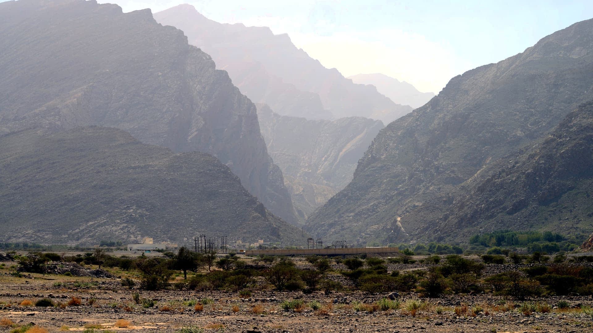 A view of a mountainous landscape featuring steep hills and valleys under a hazy sky. - Olive Oil Times