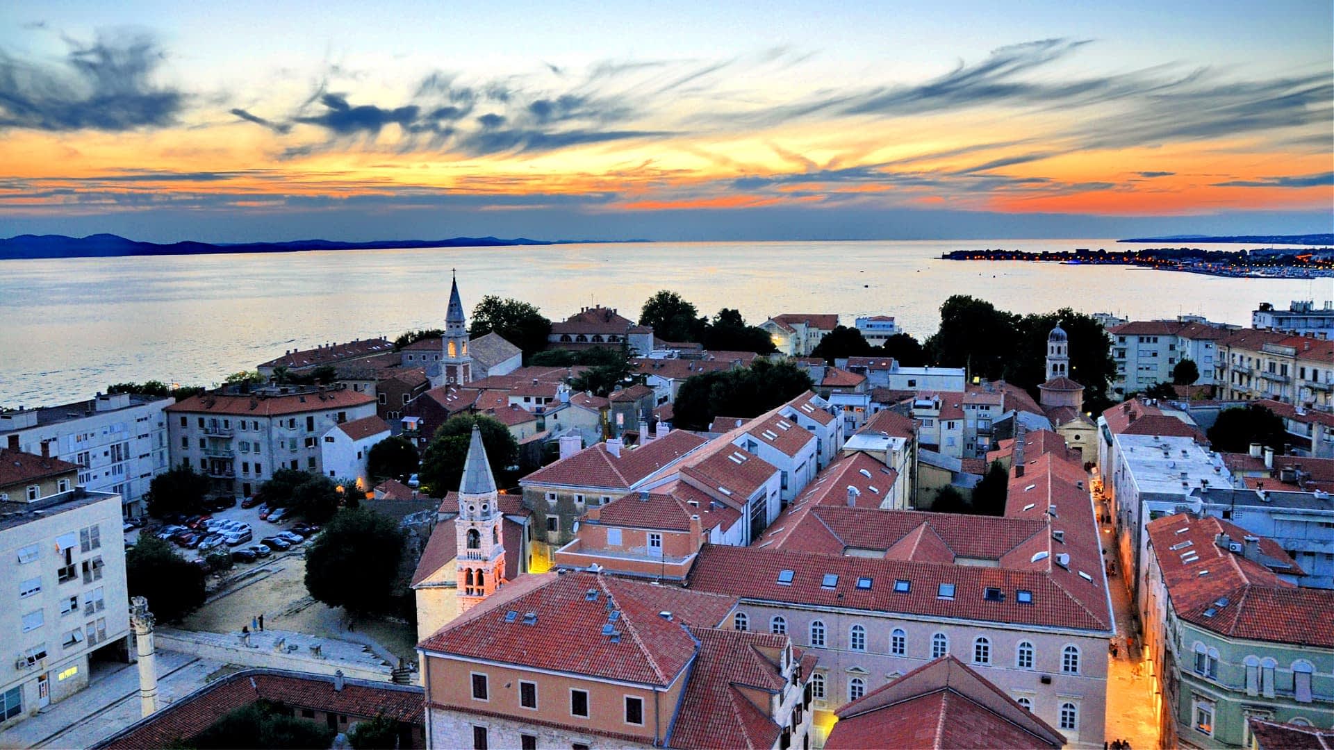 Luftaufnahme der Stadt Zadar mit Dächern und dem Meer bei Sonnenuntergang. - Olive Oil Times