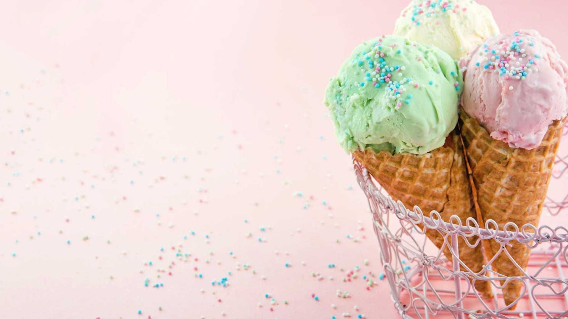 Tres conos de helado con helado verde, rosa y amarillo cubiertos con chispas de colores. Olive Oil Times
