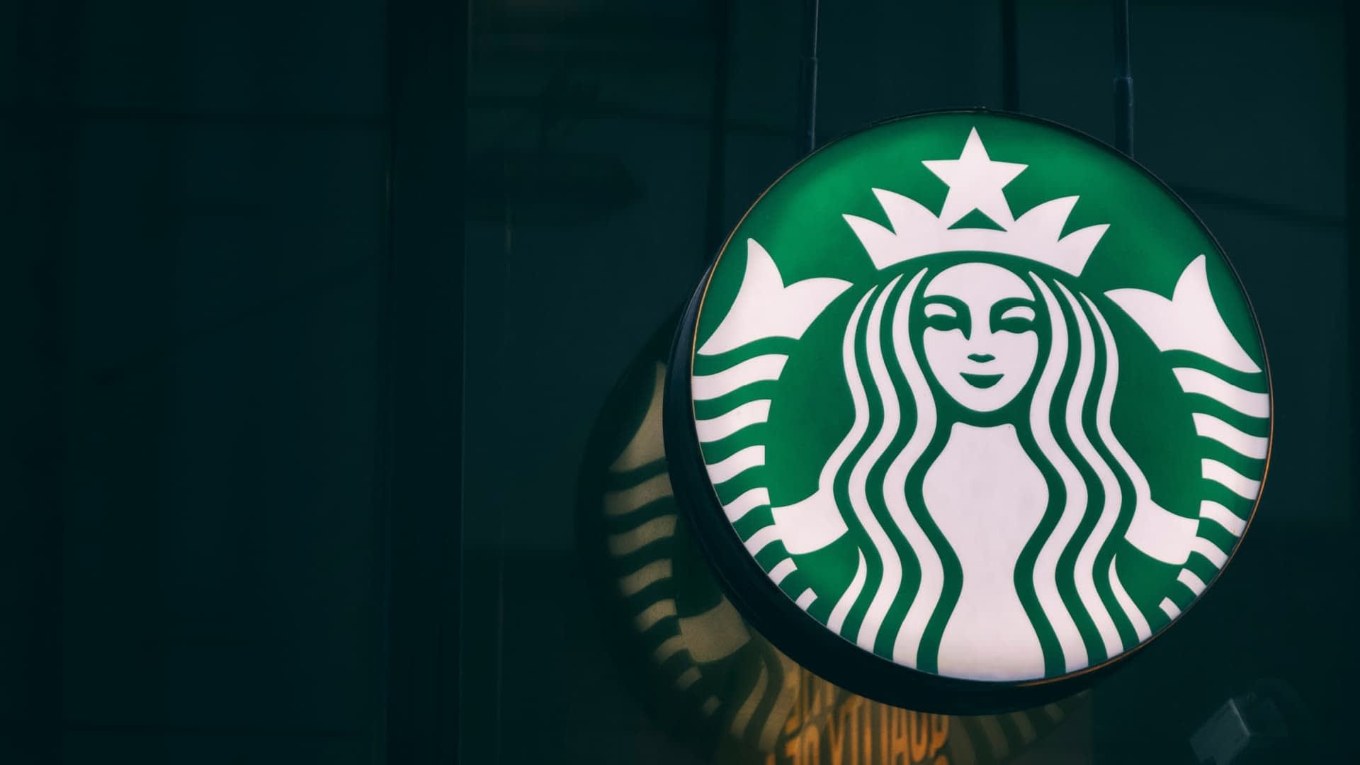 Логотип Starbucks с зеленым фоном и белой эмблемой русалки с короной. Olive Oil Times
