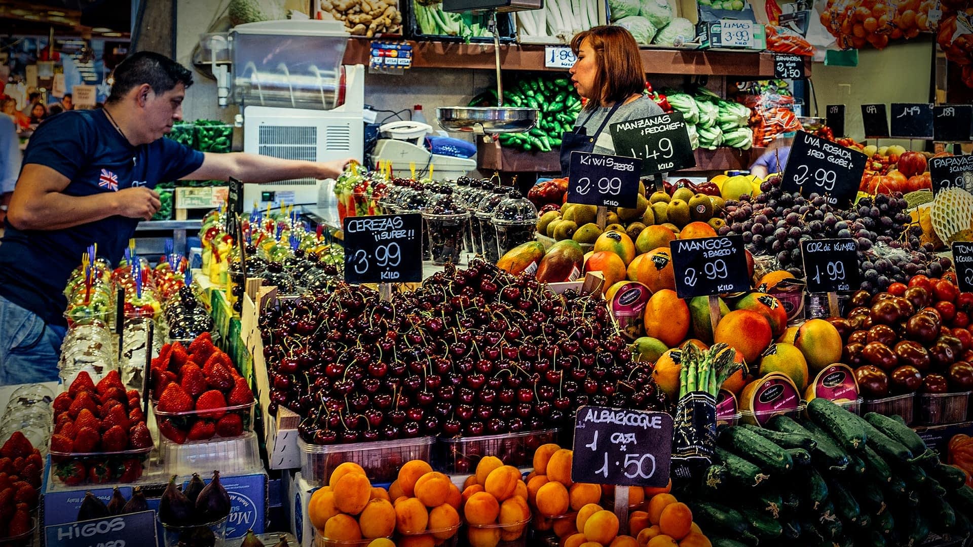 A vibrant display of various fruits and vegetables at a market stall with price tags. - Olive Oil Times