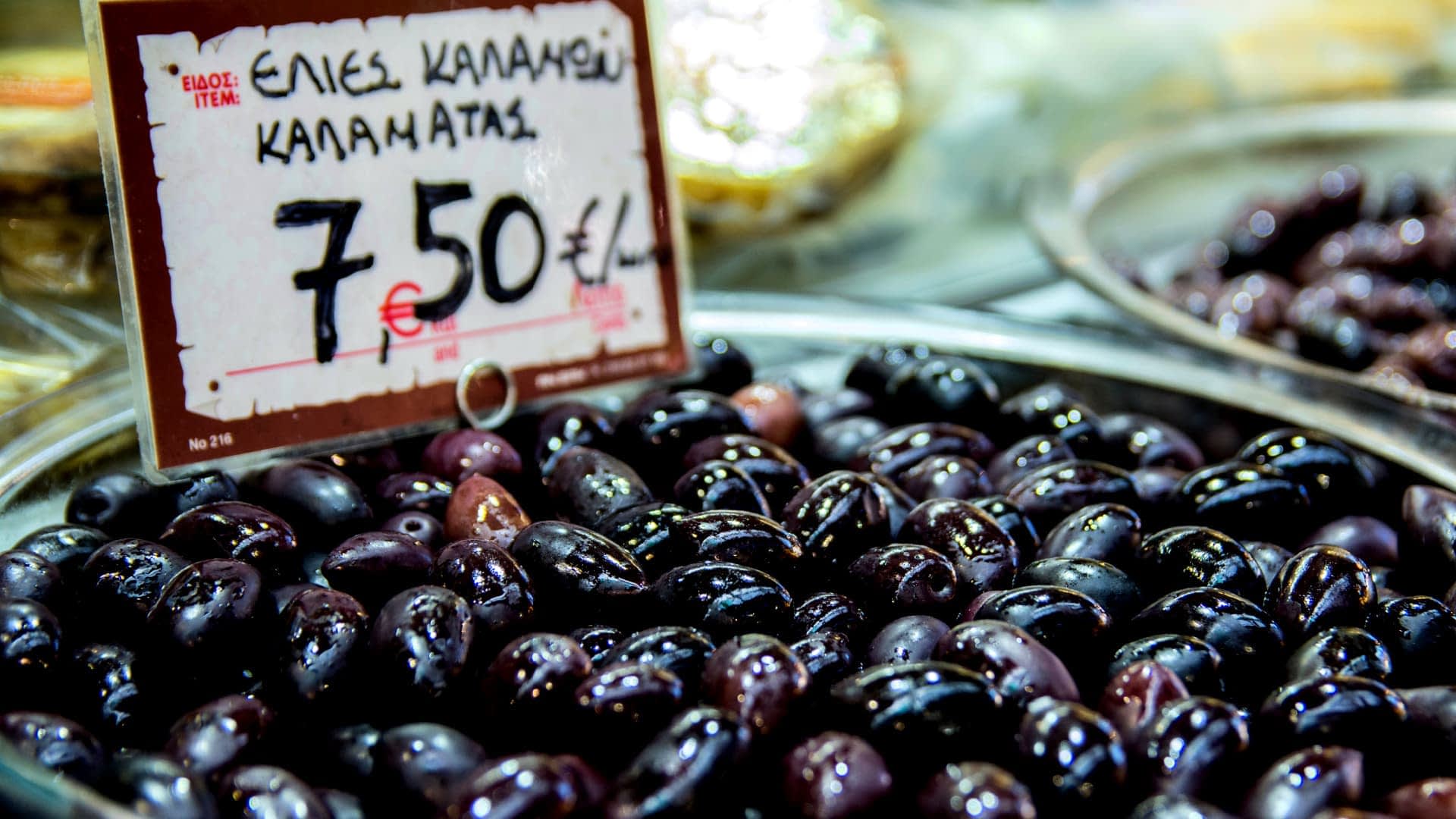 A bowl of black Kalamata olives displayed for sale with a price tag of 7.50 euros. - Olive Oil Times