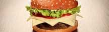A hamburger featuring a sesame seed bun, lettuce, cheese, and a beef patty. - Olive Oil Times