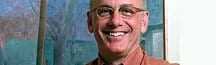 A man with glasses smiling at the camera, wearing a brown shirt. - Olive Oil Times