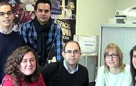 A group of six individuals posing together in an office environment, with various expressions and attire. - Olive Oil Times