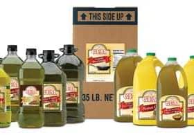 Various bottles of olive oil in different sizes alongside a cardboard box labeled with product information. - Olive Oil Times
