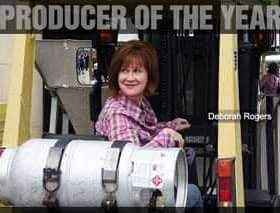 Deborah Rogers sitting on a forklift, labeled '2010 Producer of the Year'. - Olive Oil Times