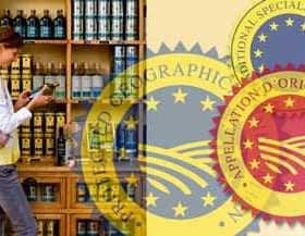 Individual standing in front of a shelf filled with olive oil bottles while using a smartphone. - Olive Oil Times