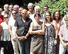 Group of individuals posing together outdoors, smiling and dressed in casual attire. - Olive Oil Times