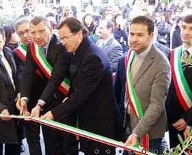 Group of officials participating in a ribbon cutting ceremony, wearing sashes and standing together. - Olive Oil Times