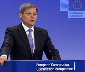 Man speaking at a podium during a European Commission press conference with a blue background. - Olive Oil Times