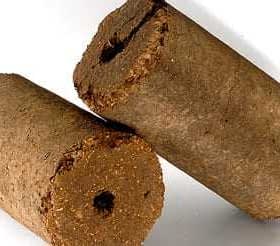 Two cylindrical olive oil briquettes with a textured surface and a hole in the center. - Olive Oil Times