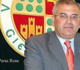 Portrait of Manuel Paras Rosa standing in front of a coat of arms emblem. - Olive Oil Times