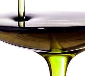 Olive oil being poured into a shallow bowl, showcasing its rich color and texture. - Olive Oil Times
