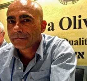 Zwei Männer sitzen an einem Konferenztisch mit einem Schild mit der Aufschrift „Terra Olivo“. – Olive Oil Times