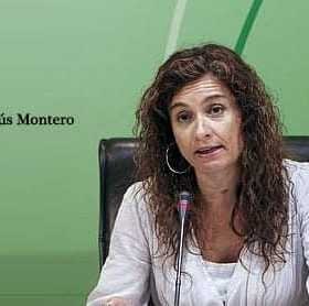 Maria Jesus Montero gestikulira med govorom na konferenci z zelenim ozadjem. - Olive Oil Times