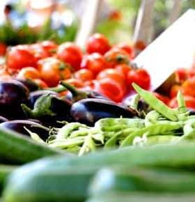 A selection of fresh vegetables including cucumbers, eggplants, and green beans displayed at a market. - Olive Oil Times