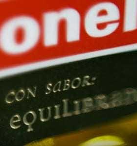 Close-up of a Carbonell olive oil label featuring text in Spanish about flavor and balance. - Olive Oil Times
