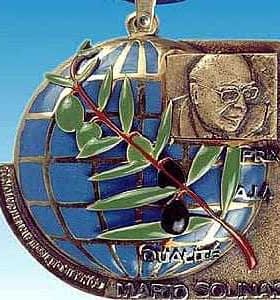 Medal featuring a globe design with an olive branch and a portrait of Mario Solinas. - Olive Oil Times