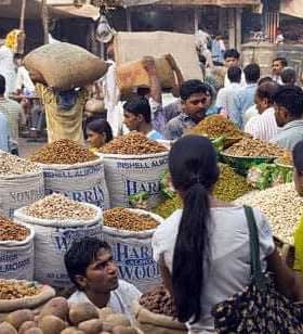 Une scène de marché animée en Inde avec de grandes piles de noix et d'épices avec de nombreuses personnes faisant leurs courses. - Olive Oil Times
