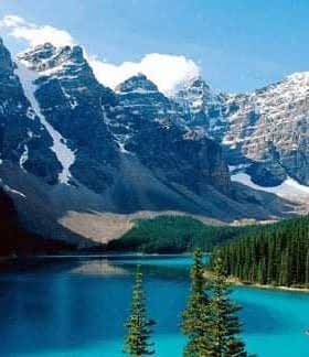 A scenic view of a mountain lake surrounded by pine trees and rocky peaks under a blue sky. - Olive Oil Times