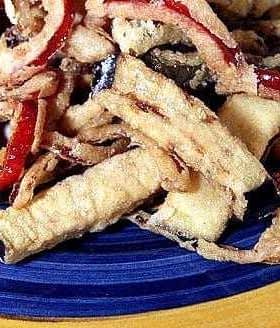 Plate of fried vegetable strips including zucchini, red pepper, and onion. - Olive Oil Times
