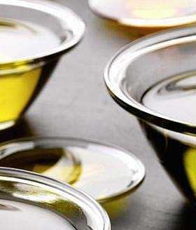 Several glass bowls containing olive oil, varying in size and filled with a golden liquid. - Olive Oil Times