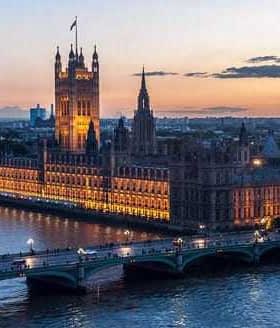 Houses of Parliament and Big Ben illuminated at sunset over the River Thames in London. - Olive Oil Times