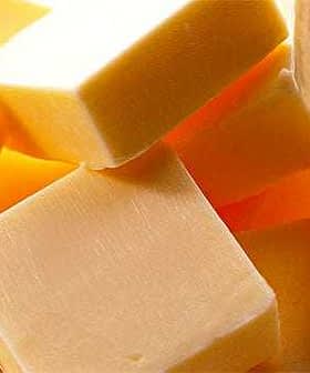 Several yellow butter cubes stacked together in a clear bowl. - Olive Oil Times