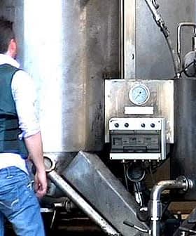 Guardia Civil officer inspecting industrial equipment in a facility. - Olive Oil Times