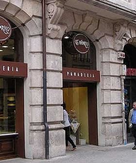 Facade of a pastry shop and bakery with signs in Spanish, featuring glass display windows. - Olive Oil Times
