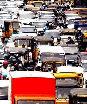 A congested traffic scene with various vehicles and people in an urban setting. - Olive Oil Times