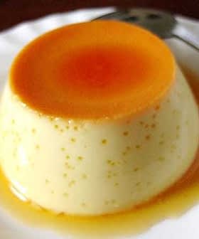 A smooth custard dessert topped with a layer of caramel sauce on a white plate. - Olive Oil Times
