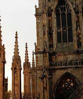 Gothic cathedral with spires and intricate stonework under a sunset sky. - Olive Oil Times