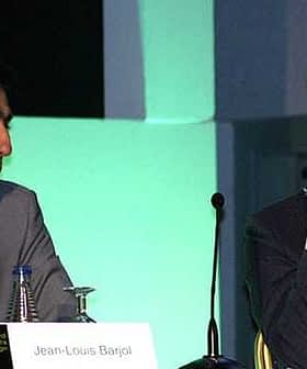Two men engaged in a panel discussion, Jean-Louis Bargal on the left and Tom Mueller on the right. - Olive Oil Times