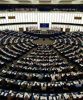 Interior view of the European Parliament with members seated in a circular arrangement. - Olive Oil Times