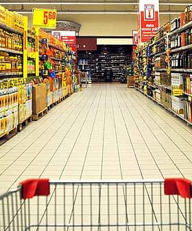 A grocery store aisle displaying various olive oil products on shelves. - Olive Oil Times