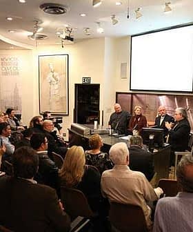 A panel discussion taking place with a seated audience in a well-lit room. - Olive Oil Times