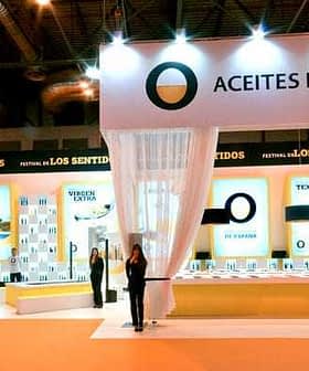Exhibition booth for Spanish olive oils featuring displays and staff at an event. - Olive Oil Times
