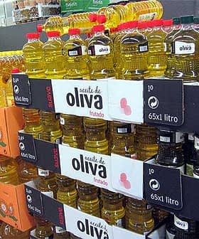 Shelves filled with various bottles of olive oil in a grocery store setting. - Olive Oil Times