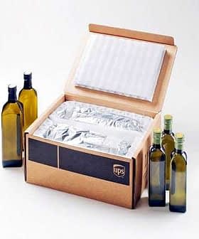 Open UPS shipping box containing wrapped olive oil bottles and packing materials. - Olive Oil Times
