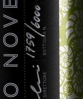 Green olive oil bottle featuring a decorative label with black and white design elements. - Olive Oil Times