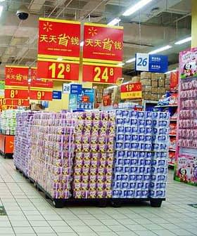 Supermarket aisle featuring stacked product displays and promotional signage in Chinese. - Olive Oil Times