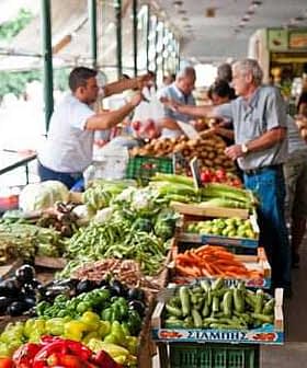 A market stall displaying a variety of fresh vegetables including peppers, cucumbers, and carrots. - Olive Oil Times