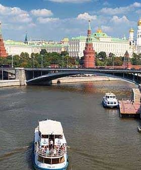 View of the Moscow River with a boat and historical buildings in the background, including the Kremlin. - Olive Oil Times