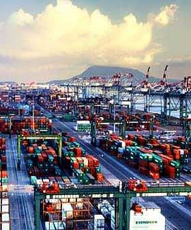 Aerial view of a busy container port filled with cargo containers and cranes. - Olive Oil Times