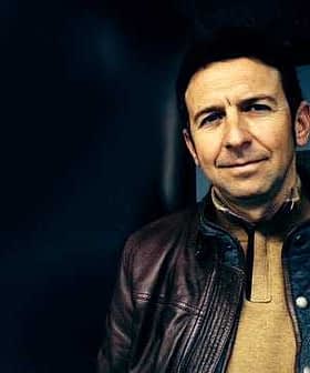 A man wearing a brown leather jacket with a neutral expression against a dark background. - Olive Oil Times